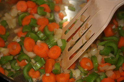 spatula stirring carrots, onion, celery