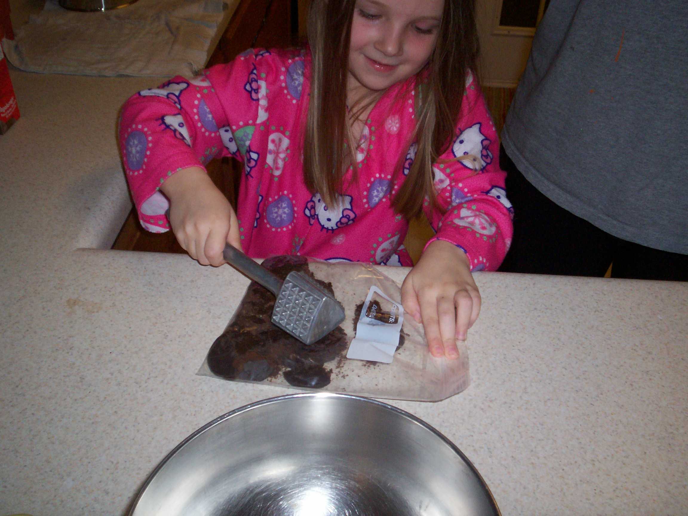 child smashing cookies in a bag