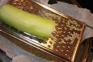 Grate the peeled and seeded cucumber over cheesecloth